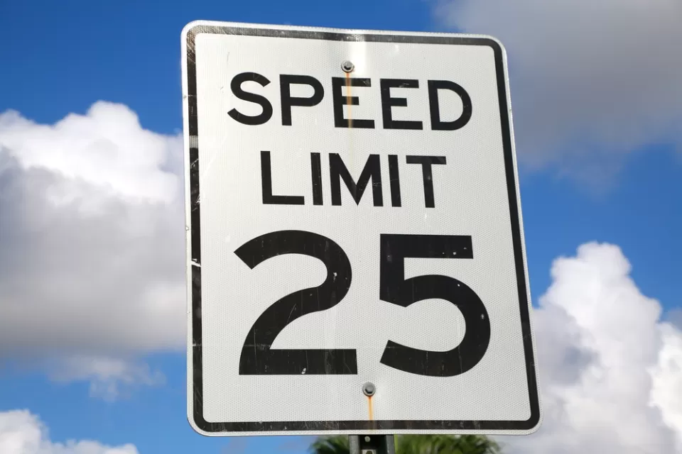 25mph speed limit sign against blue sky with white clouds